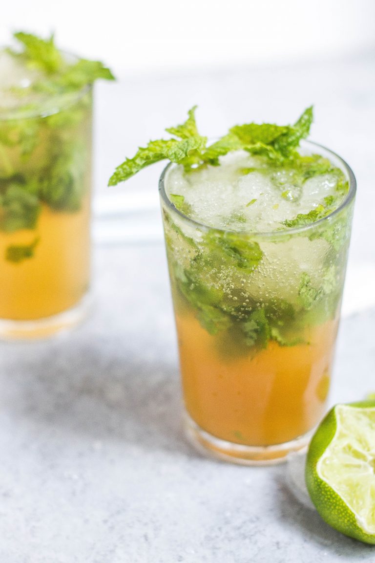 a glass of iced tea with mint leaves
